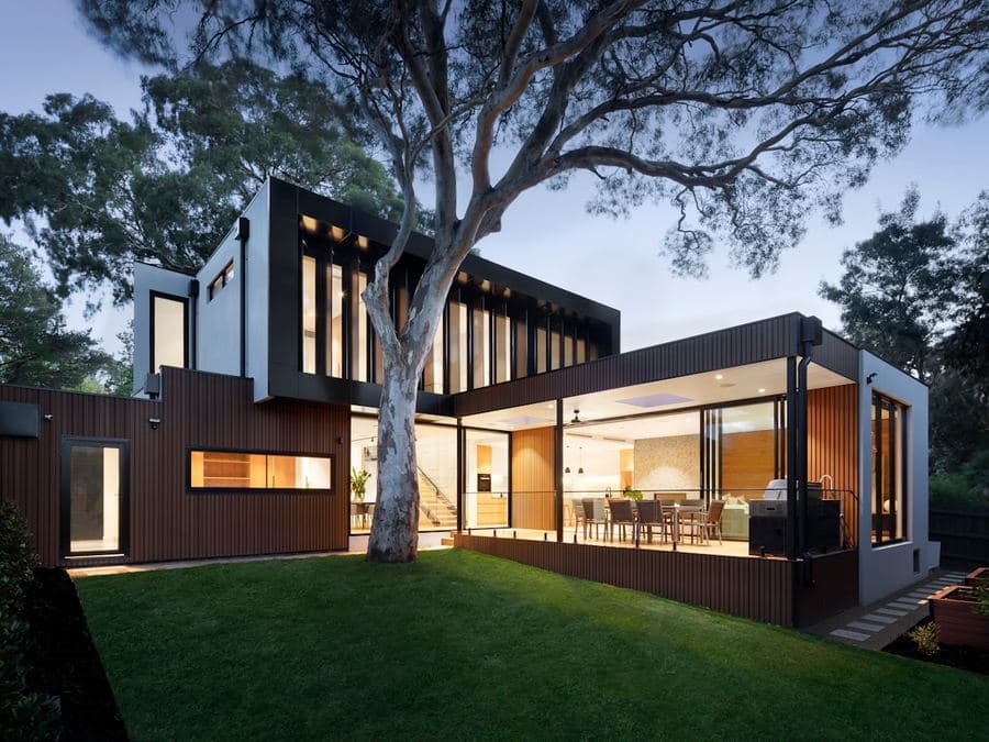 A mown lawn and mature shade tree beside a modern home